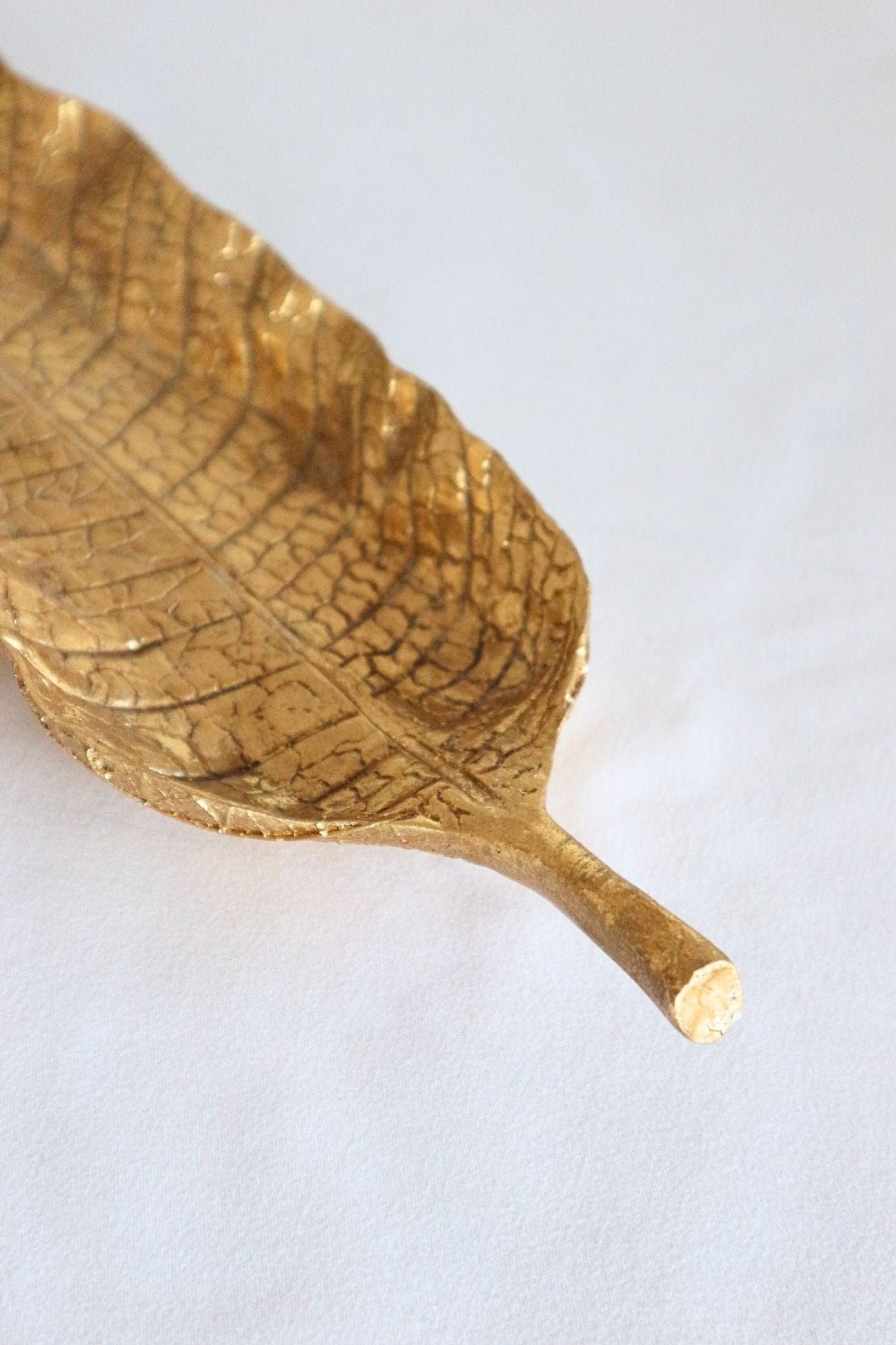 Item International Emas Emas - Svuotatasche dorato lungo a forma di foglia | Item International