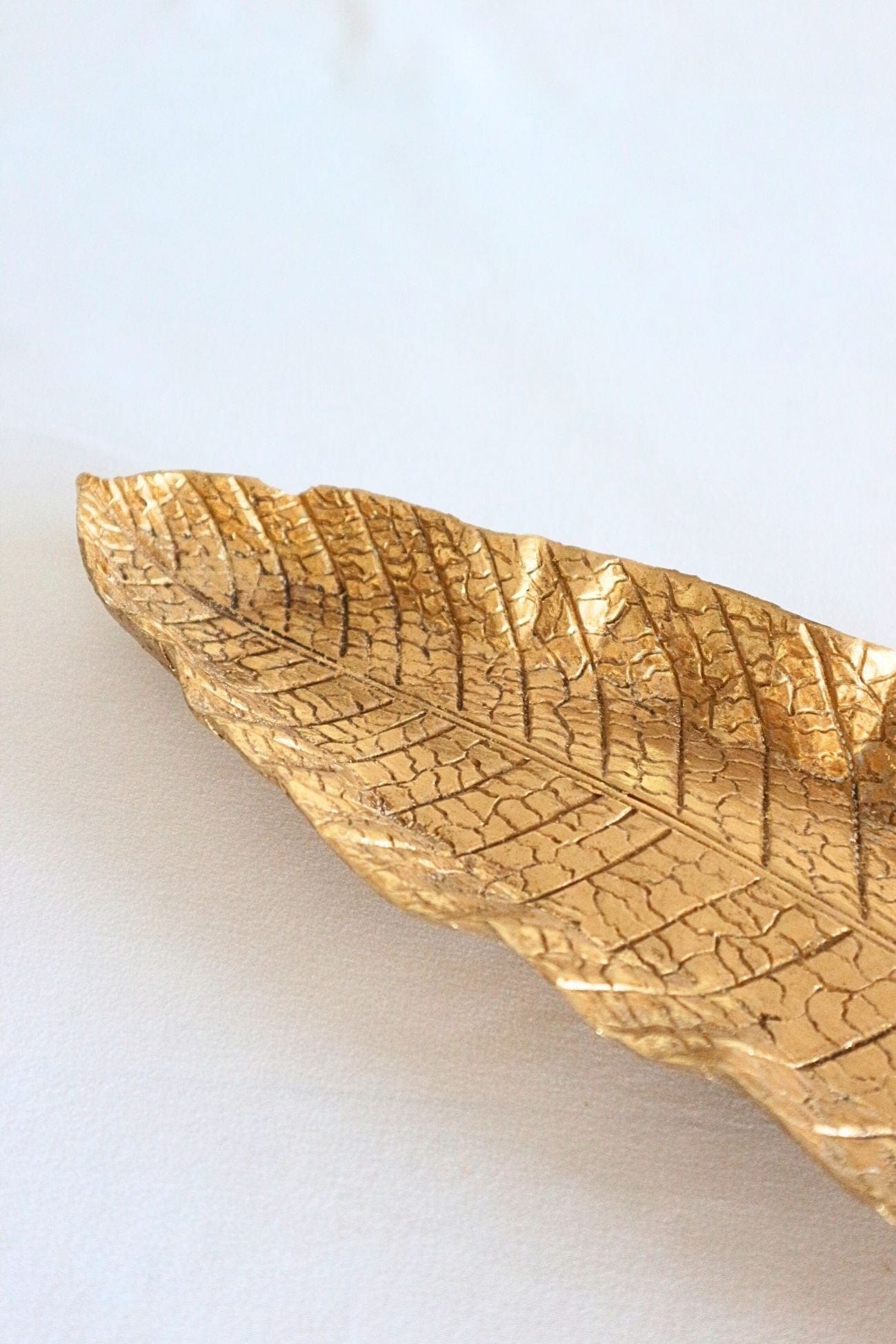 Item International Emas Emas - Svuotatasche dorato lungo a forma di foglia | Item International